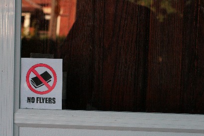 no flyers sign behind a glass door